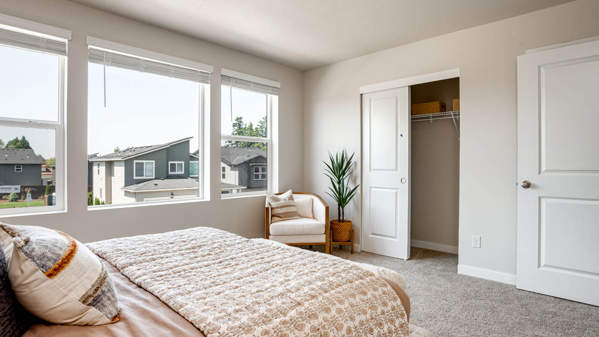 Butler Creek Crossing primary bedroom with large bed and two side tables and en suite bathroom