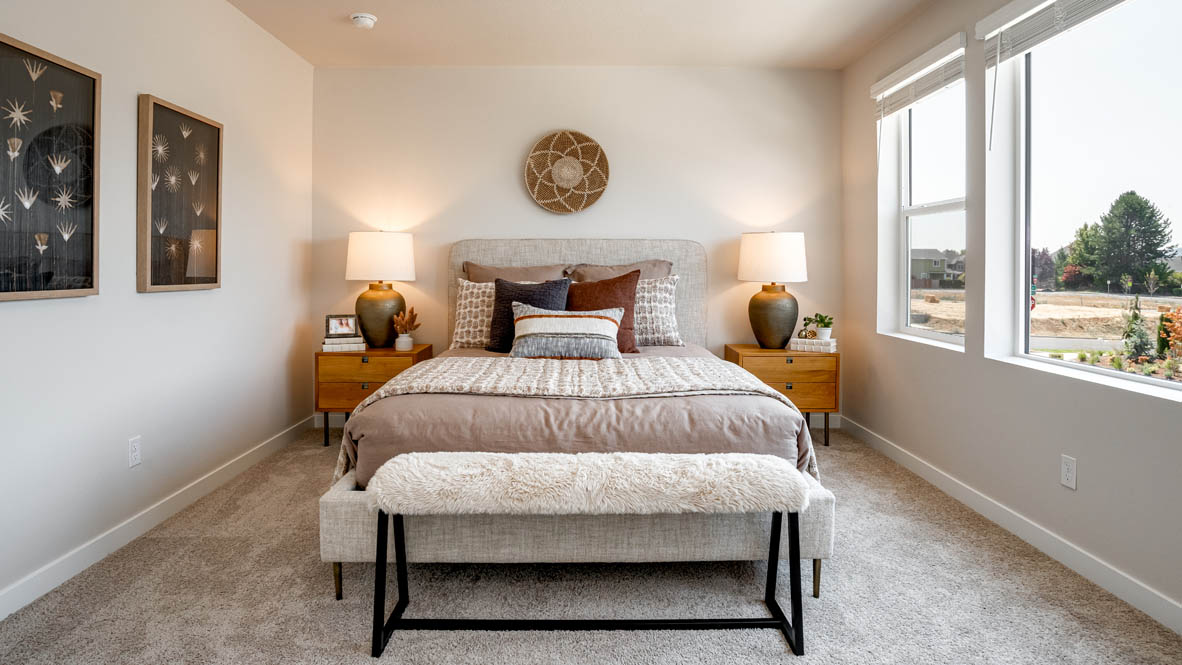 Butler Creek Crossing primary bedroom with large bed and two side tables and en suite bathroom