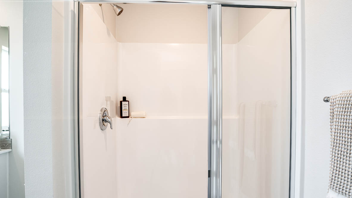 Primary bathroom with quartz counters and a walk-in shower