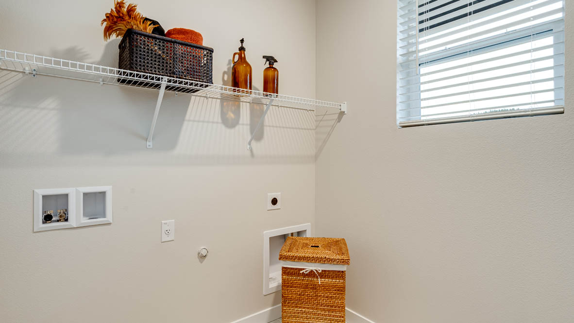 Butler Creek Crossing laundry room with white wire shelving, and a hamper