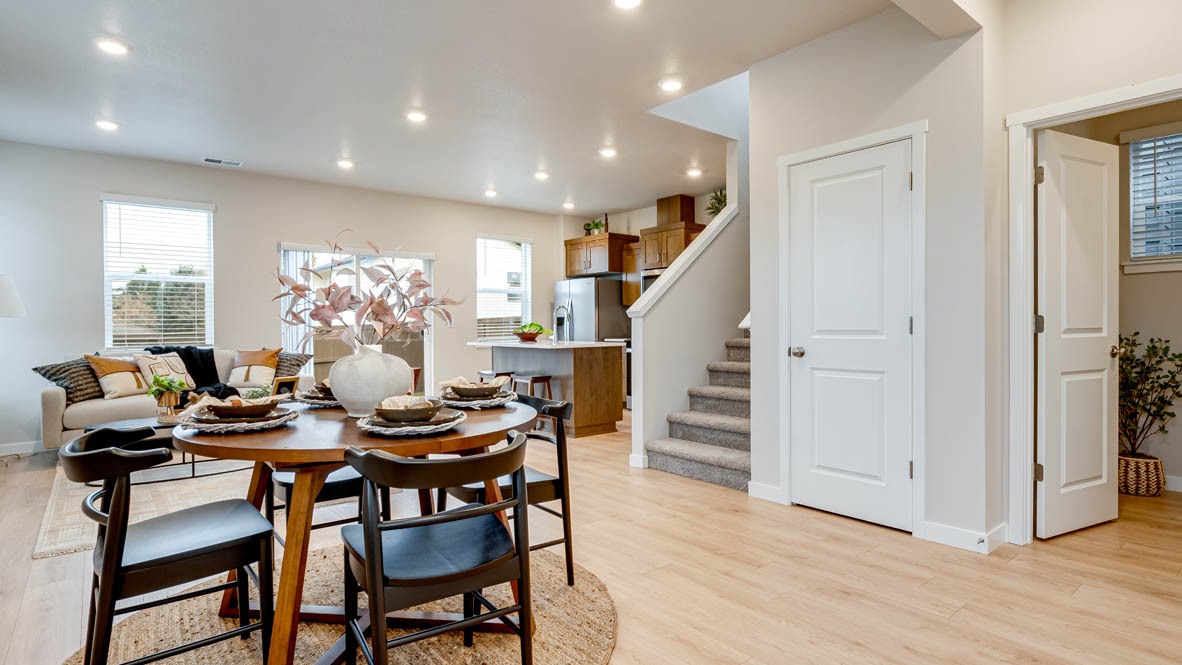 Butler Creek Crossing Dining room with four chairs set at the table placed over an area rug and connected to the great room