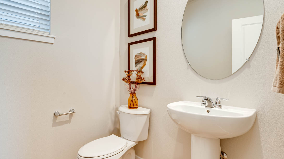 Butler Creek Crossing powder bathroom with single sink vanity, mirror, art, and blue hand towel