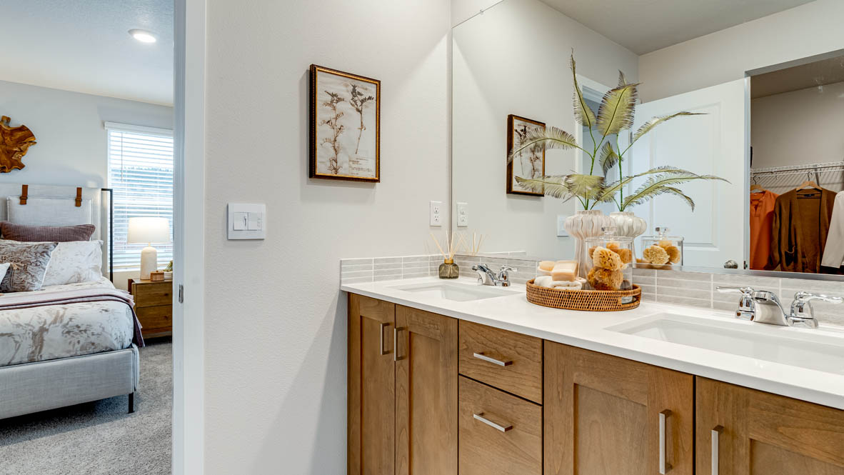 Butler Creek Crossing primary bathroom with flooring, shaker cabinets, vanity, quartz countertops, paintings, mirror