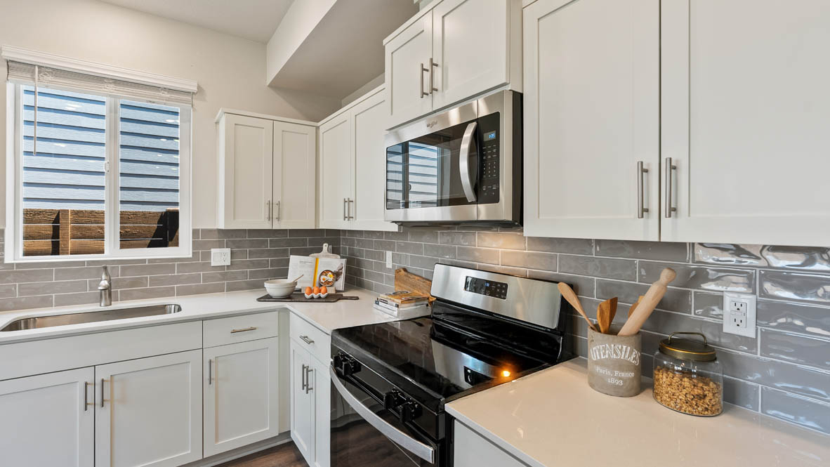 Butler Creek Crossing kitchen with window, stainless steel appliances, drawers, white stained cabinets