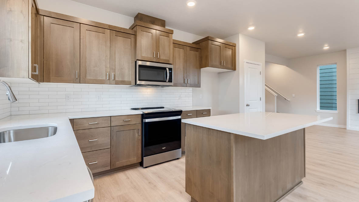 Butler Creek Crossing kitchen with window, stainless steel appliances, drawers, white stained cabinets, and pantry