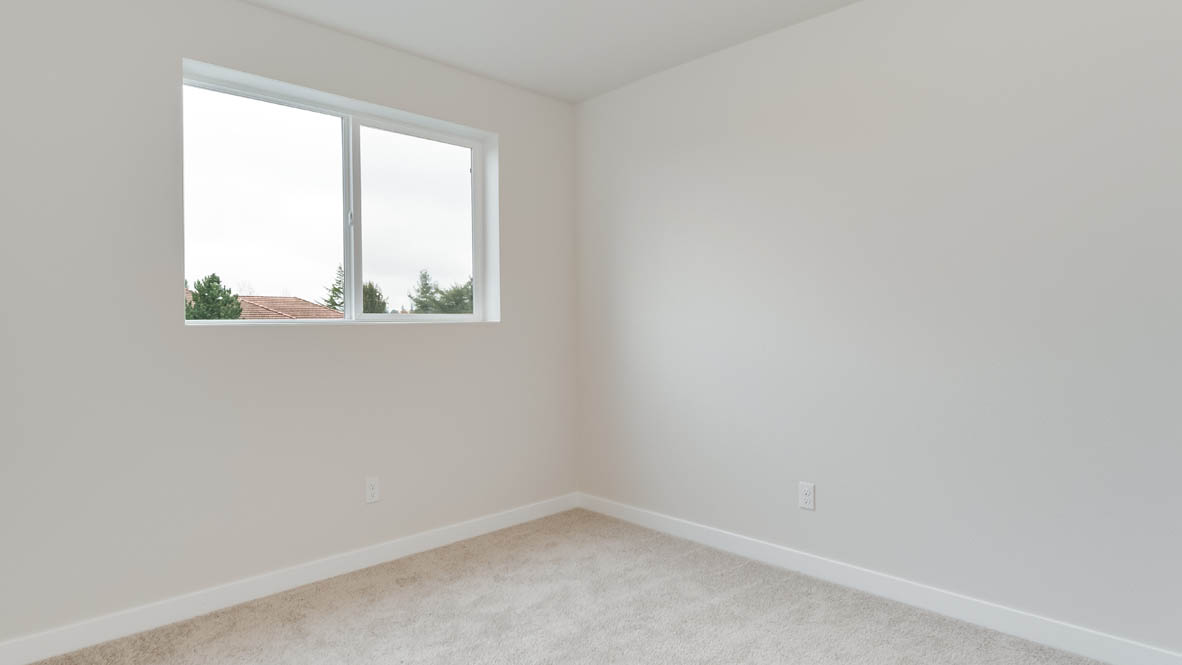 Butler Creek Crossing bedroom with window, carpet, and white walls