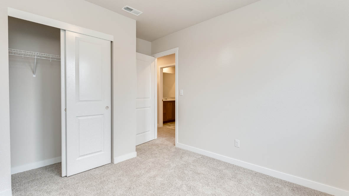 Butler Creek Crossing bedroom with a closet, carpet, and white walls