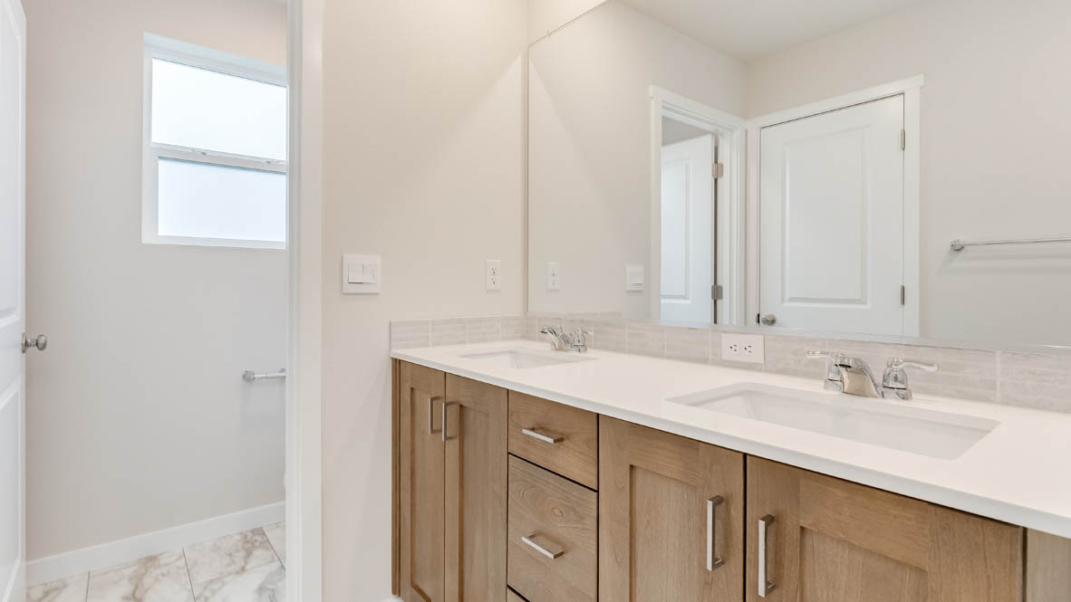 Butler Creek Crossing Primary Bathroom with countertops, cabinets, mirror, and window