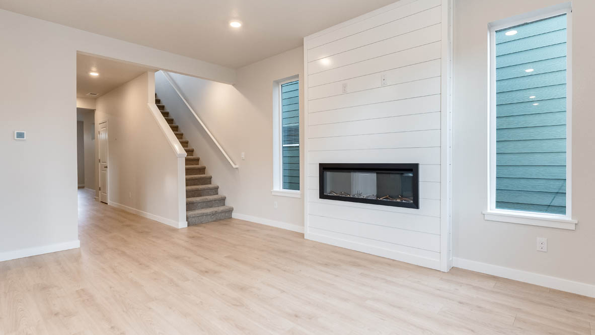 Butler Creek Crossing great room with laminate flooring, windows, and fireplace