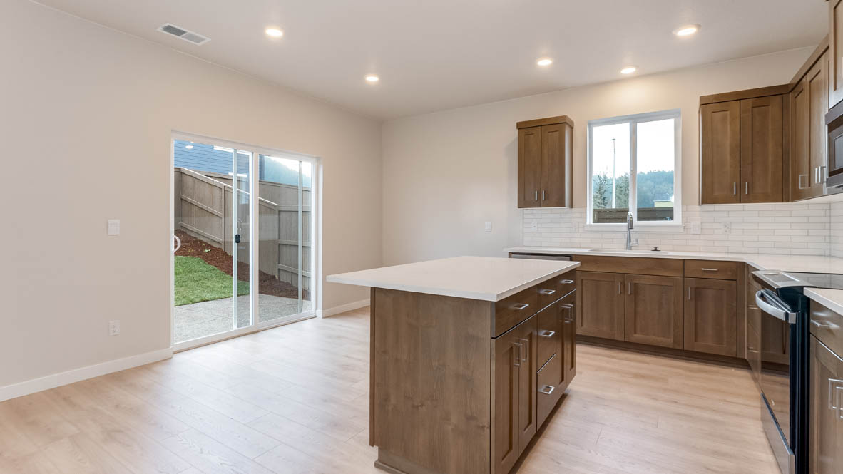 Butler Creek Crossing kitchen with window, stainless steel appliances, drawers, white stained cabinets, and pantry