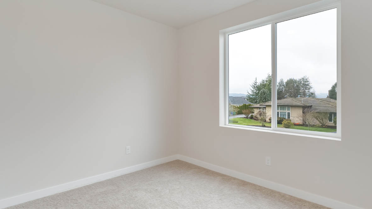 Butler Creek Crossing bedroom with window, carpet, and white walls