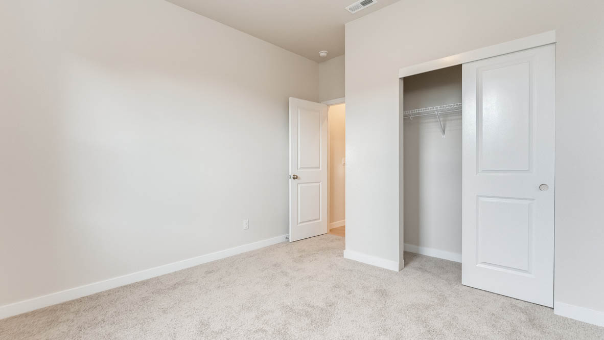 Butler Creek Crossing bedroom with a closet, carpet, and white walls