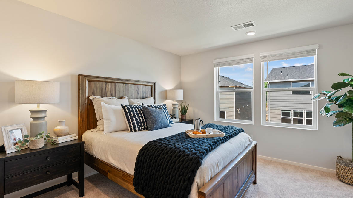 Butler Creek Crossing primary bedroom with carpet, windows, nightstand with lamp, and plant