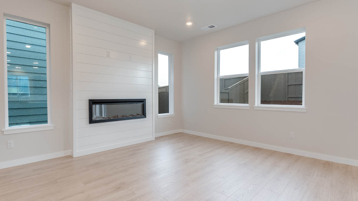 Butler Creek Crossing great room with laminate flooring, windows, and fireplace