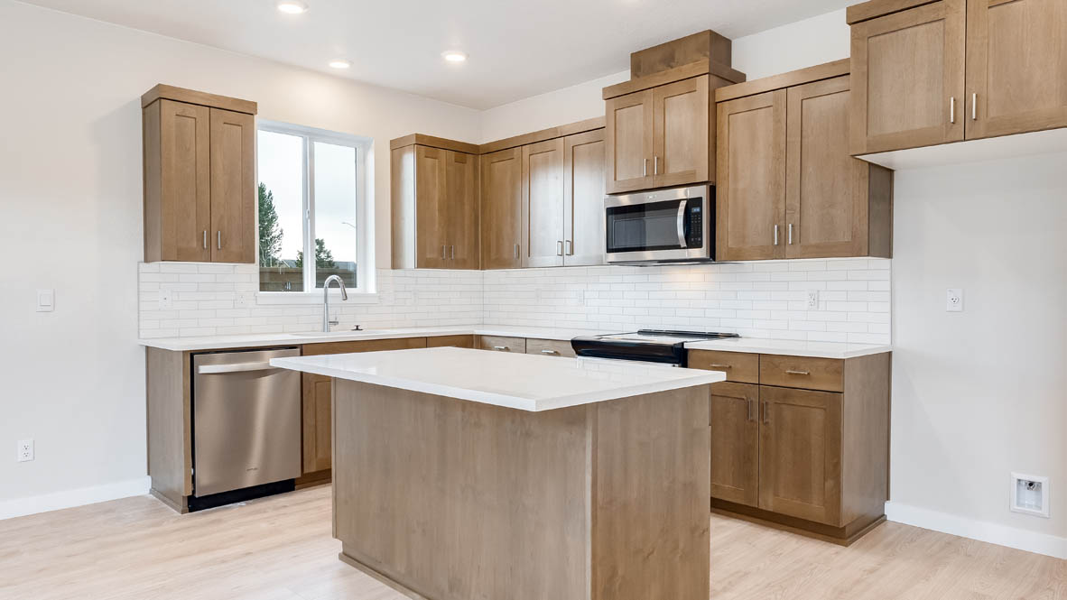 Butler Creek Crossing kitchen with window, stainless steel appliances, drawers, white stained cabinets, and pantry