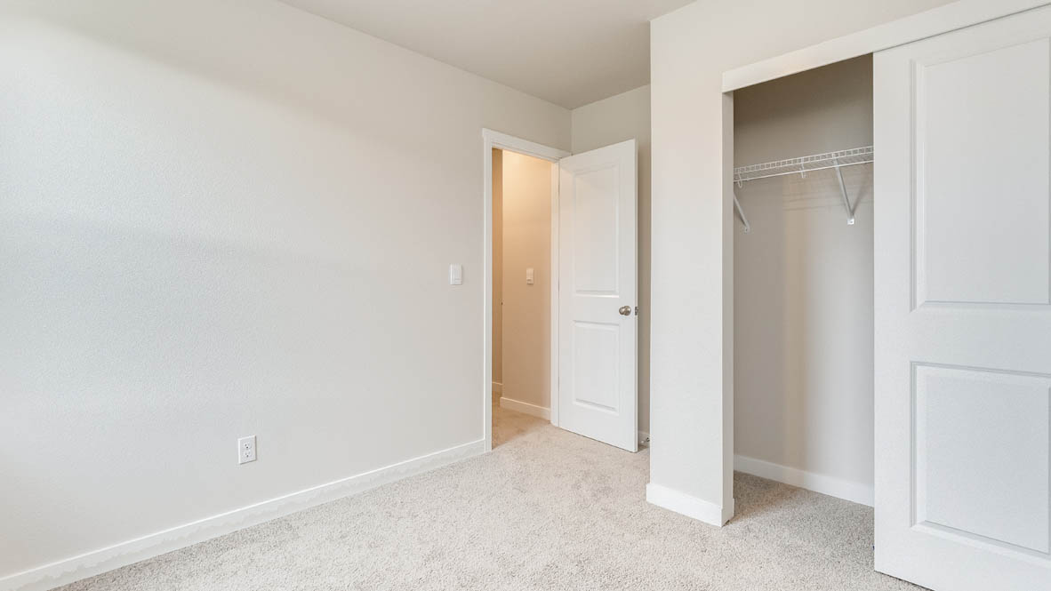 Butler Creek Crossing bedroom with a closet, carpet, and white walls