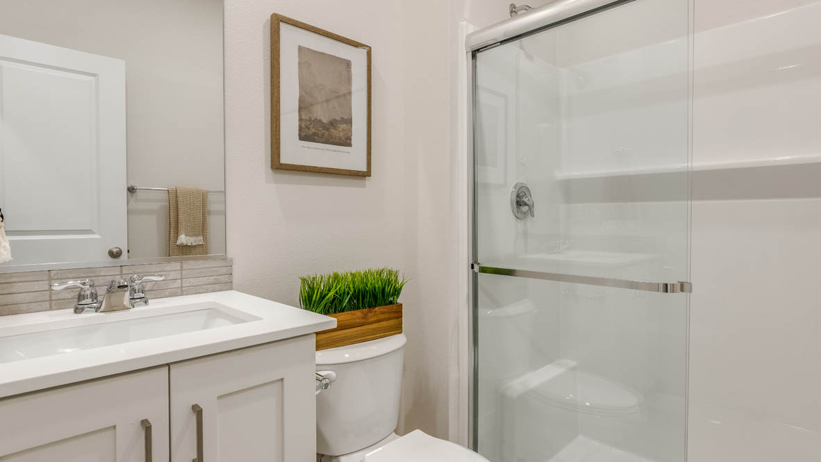 Butler Creek Crossing bathroom with single sink vanity, mirror, art, towel, and walk in shower