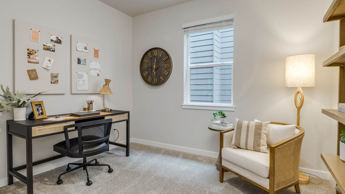 Butler Creek Crossing bedroom with side table and a lamp, bed, paintings, desk with a chair, and window with shades, and a closet