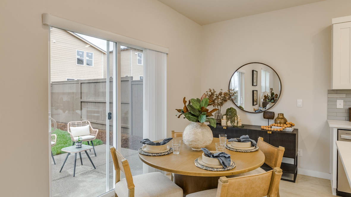 Butler Creek Crossing Dining room with four chairs set at the table placed over an area rug and connected to the great room