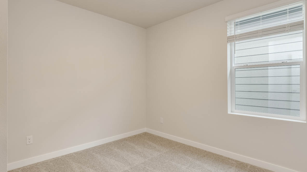 Butler Creek Crossing bedroom with side table and a lamp, bed, paintings, desk with a chair, and window with shades