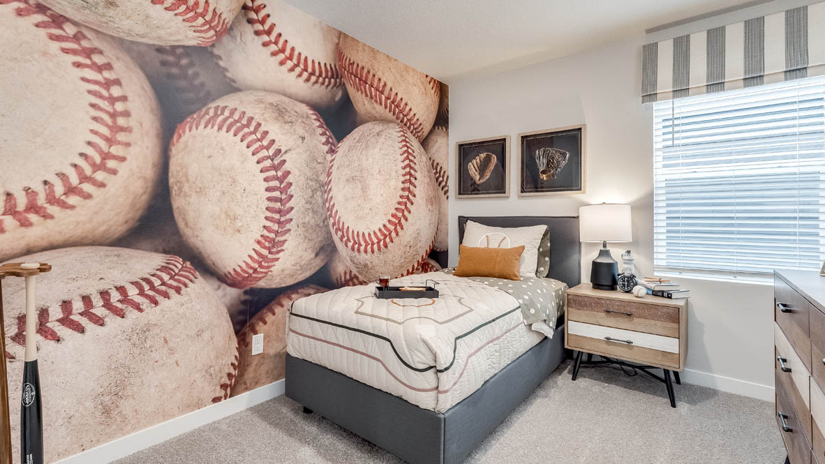 Butler Creek Crossing bedroom with side table and a lamp, bed, paintings, desk with a chair, and window with shades