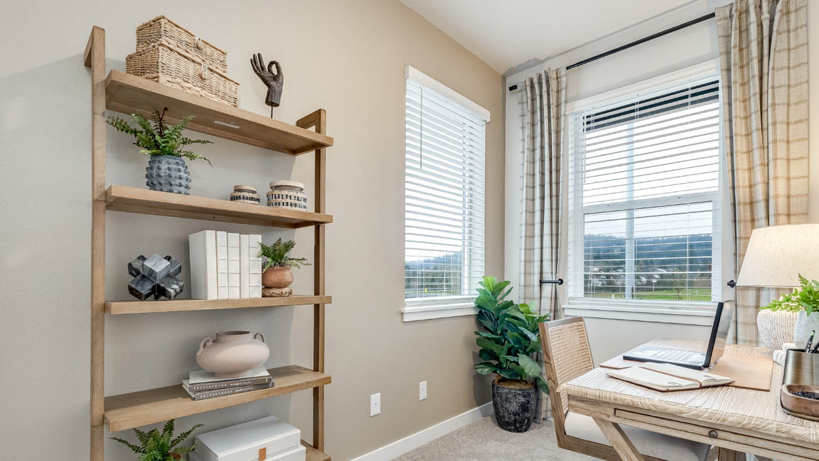 Butler Creek Crossing Den set up as an office with a desk, shelves, and plants