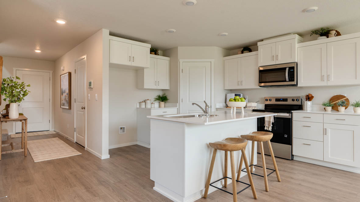 Bailey Meadows kitchen with white shaker style cabinets, solid surface countertops, and stainless steel appliances