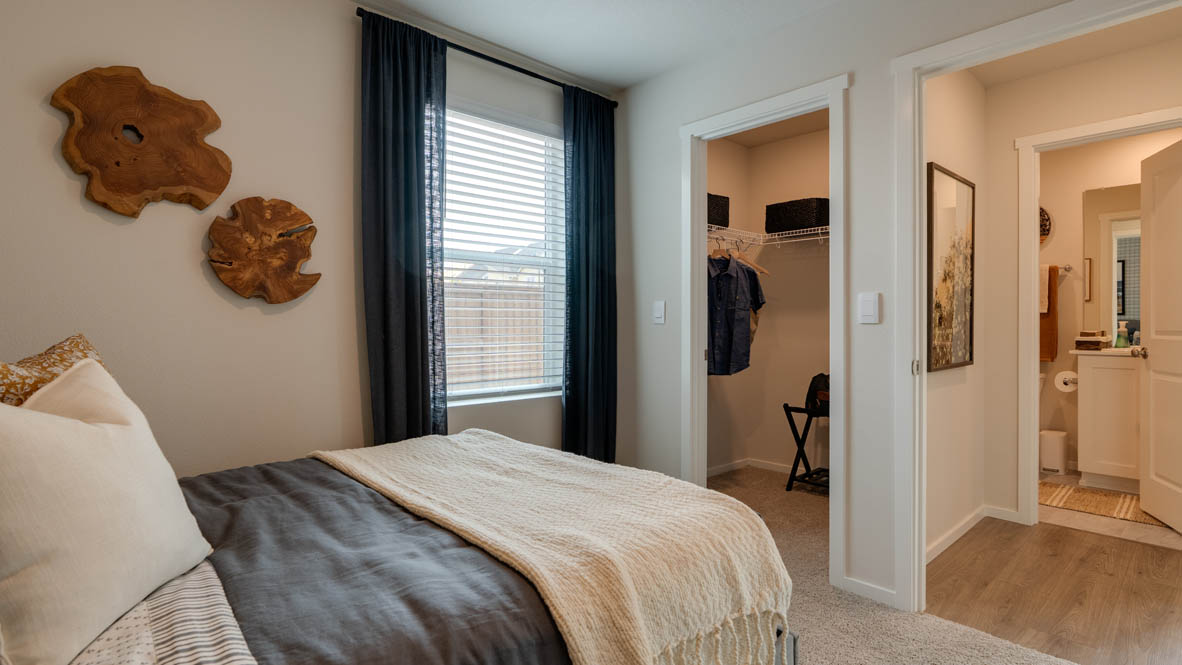 Bailey Meadows bedroom on the main level with carpeting and an en suite bathroom