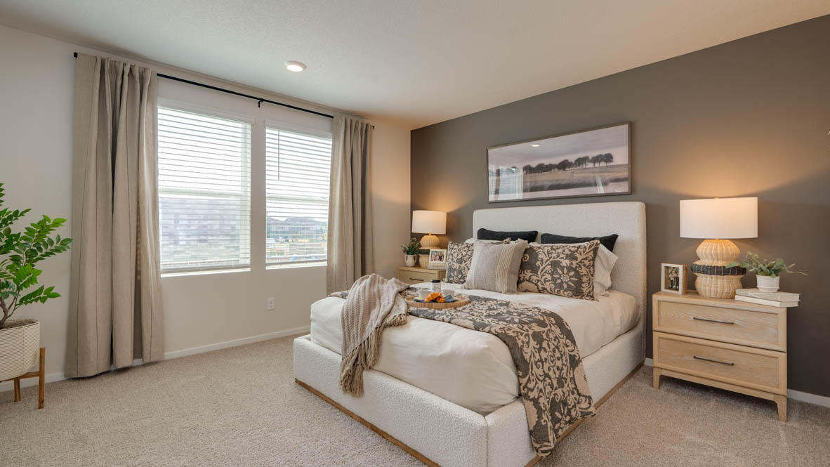 Bailey Meadows primary bedroom with accent wall and carpeting with light colored wooden furniture