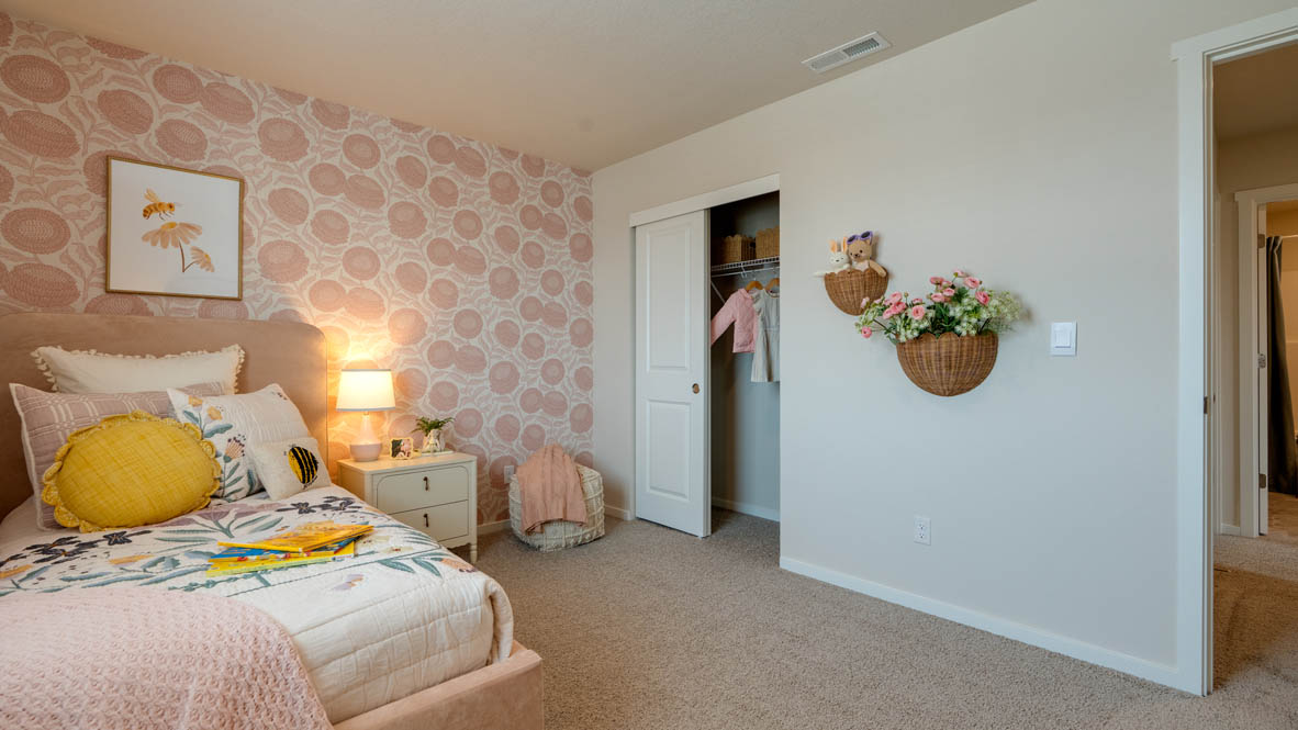 Bailey Meadows bedroom with pink decor and twin bed and carpeting