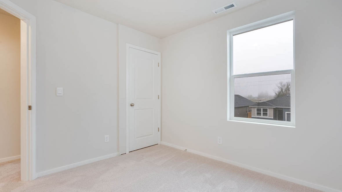 East Park Village bedroom with white carpeting, white walls, and white closet doors