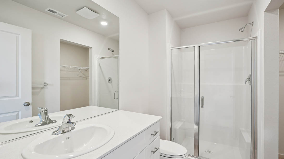 East Park Village primary bedroom with white carpeting, white walls and en suite bathroom