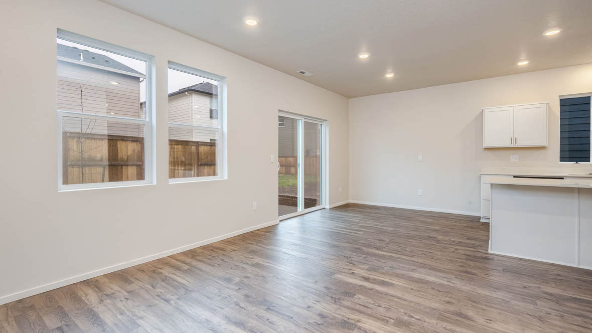 East Park Village dining area with laminate flooring, windows, white walls, and glass sliding door