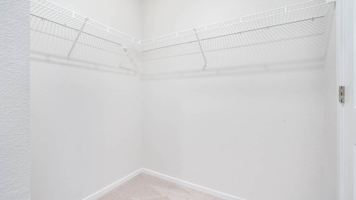East Park Village walk in closet with white wire shelving and carpet