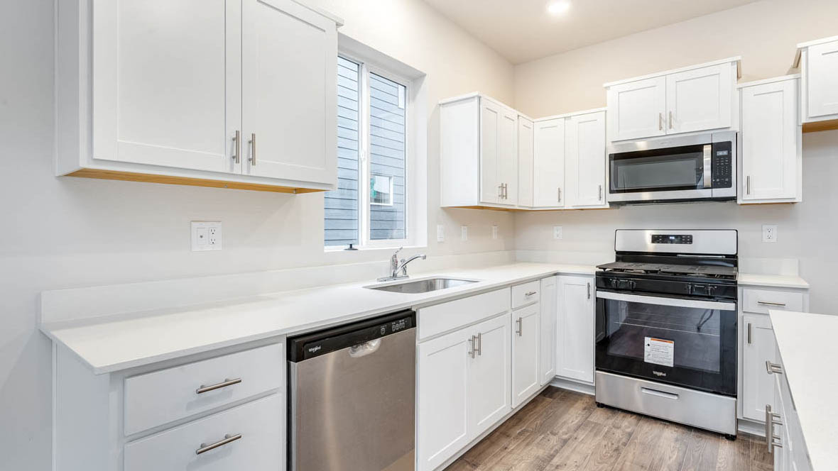 East Park Village kitchen with white shaker style cabinets and white quartz countertops