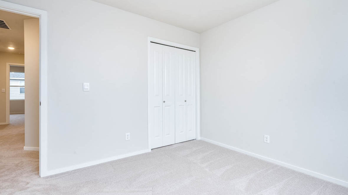 East Park Village bedroom with white carpeting, white walls, and white closet doors