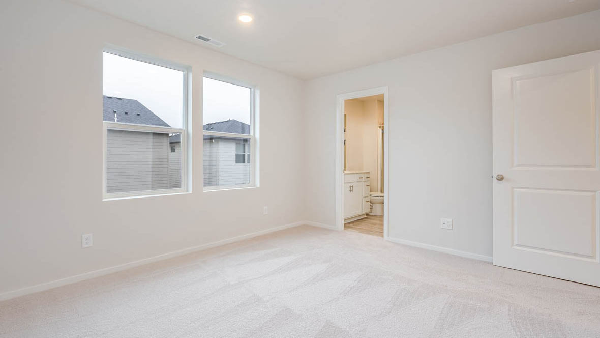 East Park Village primary bedroom with white carpeting, white walls and en suite bathroom