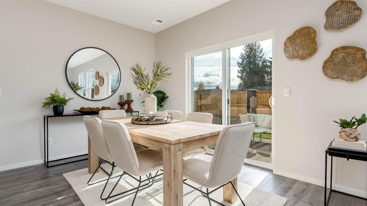 East Park Village Dining Room with four chairs, a table, a plant, sliding glass door, hanging decorations, a side table, a console table with plants and a mirror