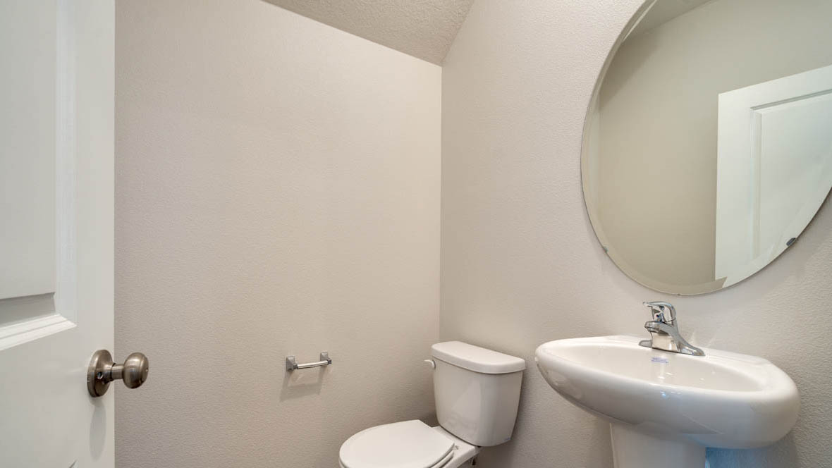 East Park Village powder bathroom with sink, mirror, and toilet