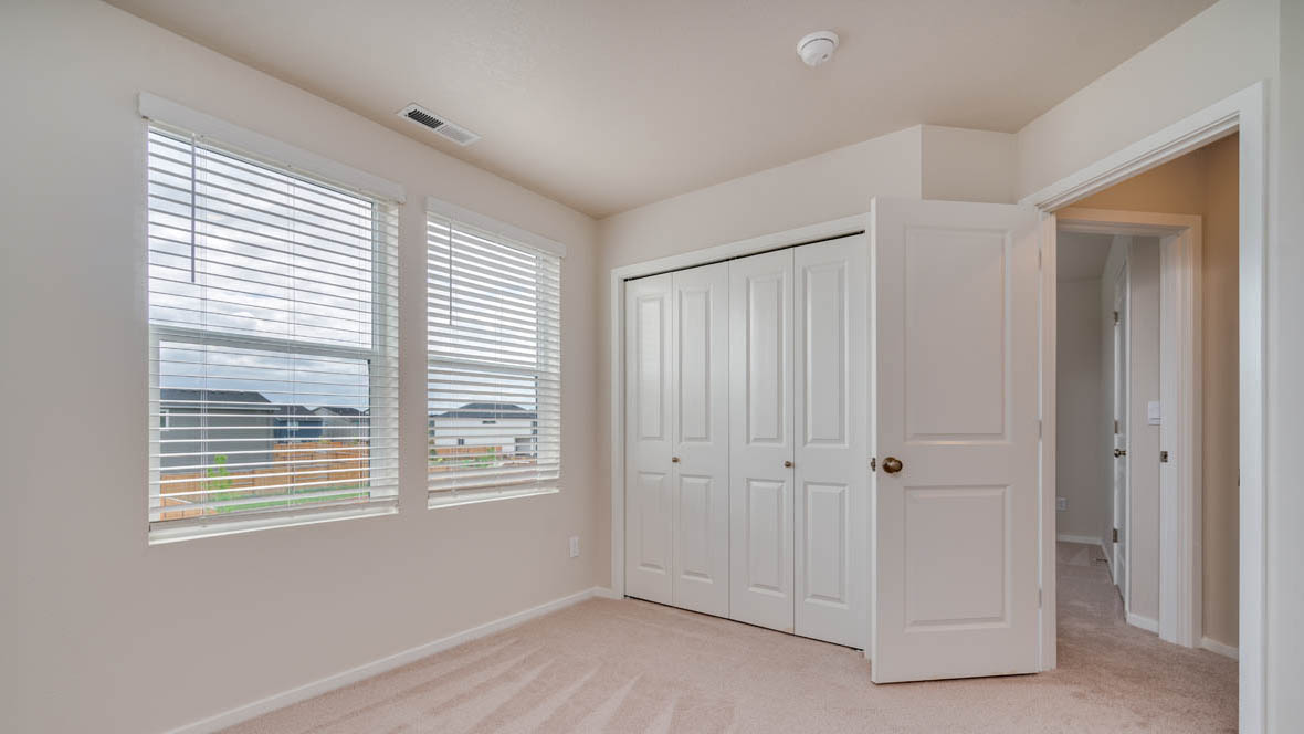 East Park Village bedroom with carpet, closet, white walls, and window