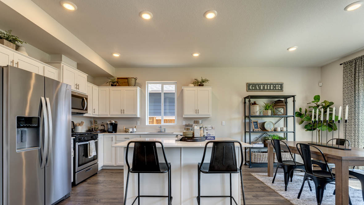 East Park Village kitchen with white cabinets, stainless steel appliances, and laminate flooring