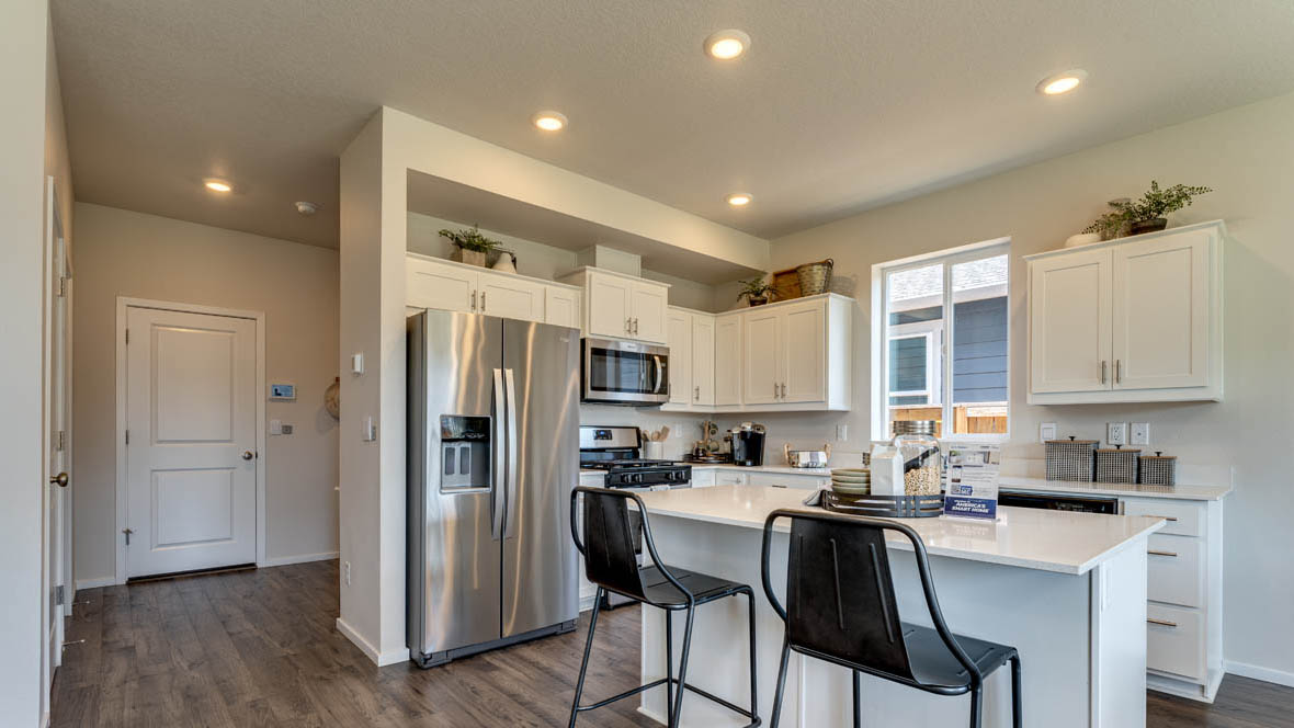 East Park Village kitchen with white cabinets, stainless steel appliances, and laminate flooring
