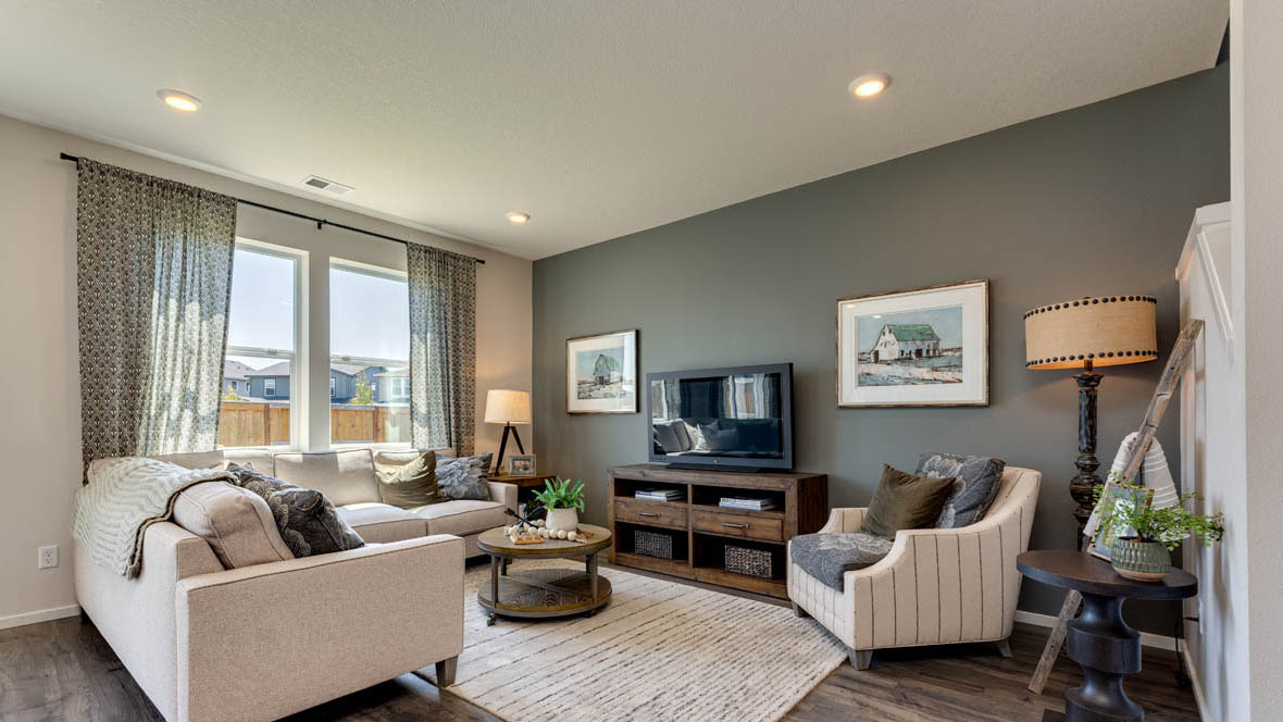 East Park Village great room with laminate flooring, accent wall, and light colored furniture