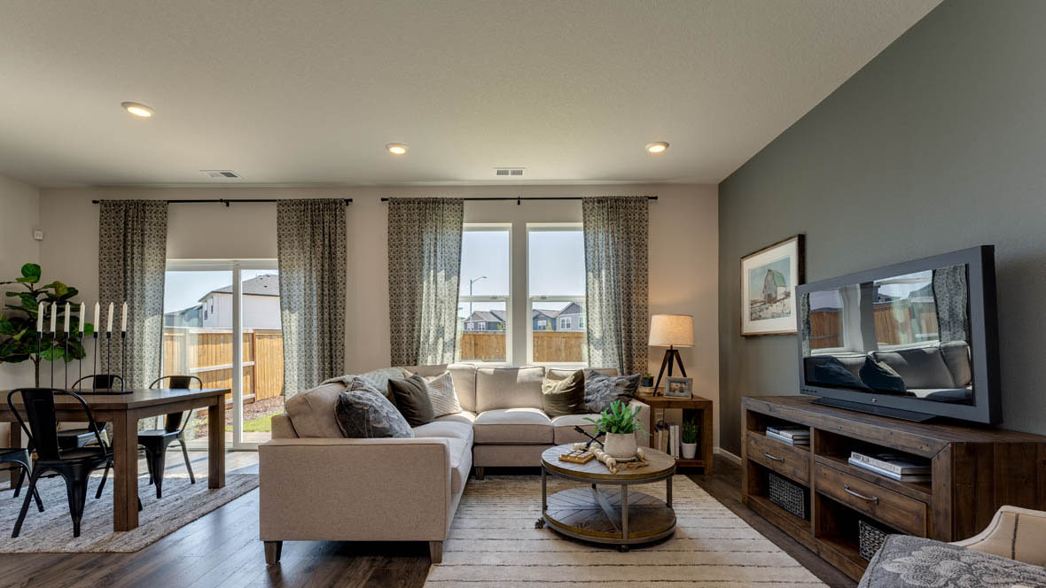 East Park Village great room with laminate flooring, accent wall, windows, and light colored furniture