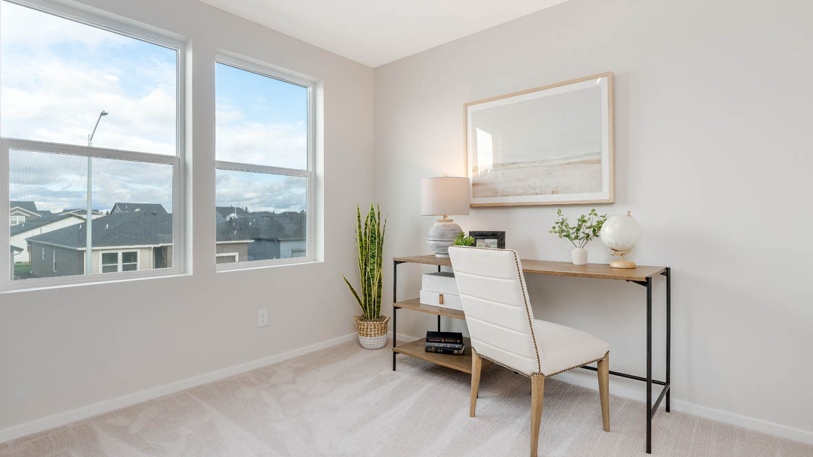 East Park Village Bedroom with a bed with sheets, light stained bed frame, end table with a lamp, paintings, and a window