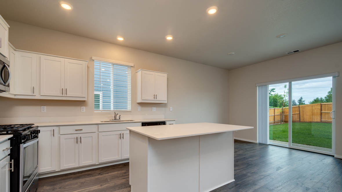 East Park kitchen with shaker style white cabinets, island, and solid surface countertops