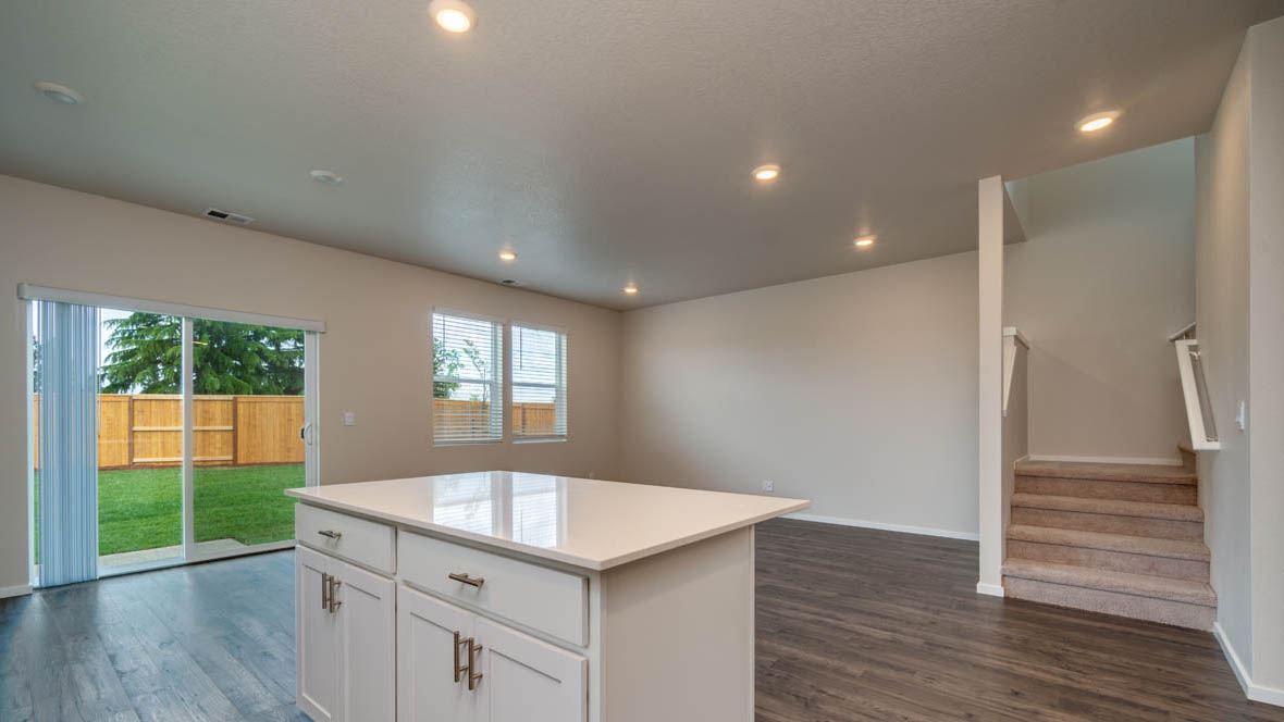 East Park kitchen with shaker style white cabinets, island, and solid surface countertops