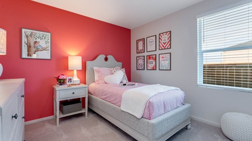 East Park Village bedroom with pink accent wall and pink theme with twin bed and white furniture
