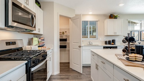 East Park Village Kitchen with white shaker style cabinets, white quartz countertops, stainless steel appliances and pantry