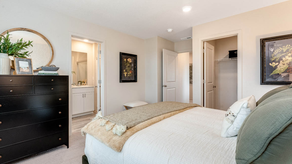 East Park Village Primary bathroom with double vanity, white quartz countertops, plants, white cabinets, walk-in shower with sliding glass door